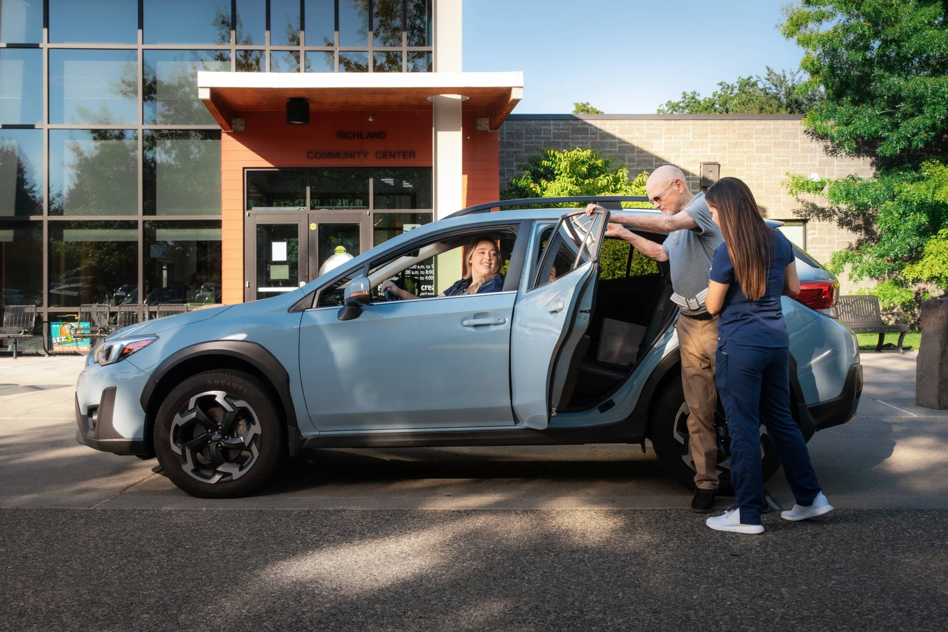 A patient gets into a car with staff assistance our transportation services